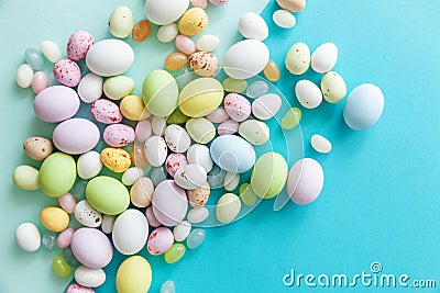 Happy Easter concept. Easter candy chocolate eggs and jellybean sweets isolated on trendy pastel blue background. Simple Stock Photo