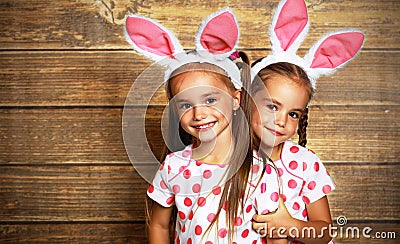 Happy easter! cute twins girls sisters dressed as rabbits on wo Stock Photo