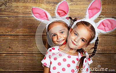 Happy easter! cute twins girls sisters dressed as rabbits on wo Stock Photo