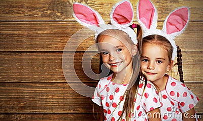 Happy easter! cute twins girls sisters dressed as rabbits on wo Stock Photo