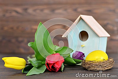 Happy Easter: Easter egg in the nest, birdhouse and spring flowers Stock Photo