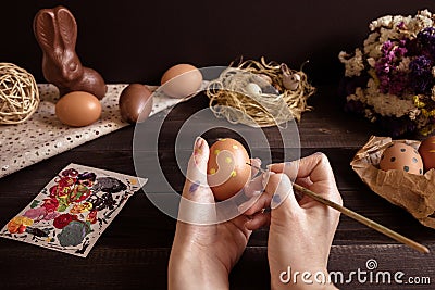 Happy easter. Female hands painting easter egg on the wooden table Stock Photo