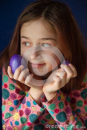 Happy easter. Girl and colored eggs in purple. Traditions of Easter. Teenager, girl 9 years old. Girl with a quack Stock Photo