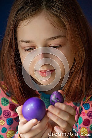 Happy easter. Girl and colored eggs in purple. Traditions of Easter. Teenager, girl 9 years old. Girl with a quack Stock Photo