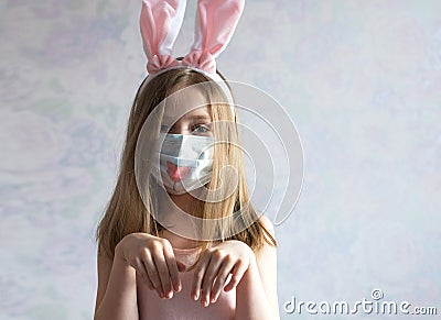 happy Easter. A littel girl with long blonde hair in rabbit ears. She is wearing a medical mask painted with a muzzle Stock Photo