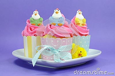 Happy Easter pink, yellow and blue cupcakes with cute chicken decorations Stock Photo