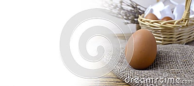 Happy Easter rustic background banner. Brown egg on sacking fabric over tradition festive composition. Stock Photo