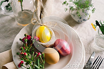 Happy Easter. Stylish easter eggs on a napkin with spring flowers on white wooden background Stock Photo