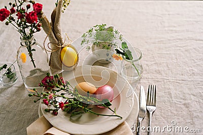 Happy Easter. Stylish easter eggs on a napkin with spring flowers on white wooden background Stock Photo