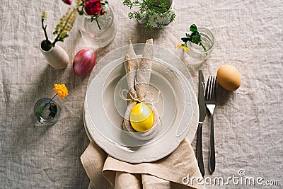 Happy Easter. Stylish easter eggs on a napkin with spring flowers on white wooden background Stock Photo