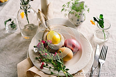 Happy Easter. Stylish easter eggs on a napkin with spring flowers on white wooden background Stock Photo