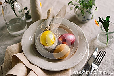 Happy Easter. Stylish easter eggs on a napkin with spring flowers on white wooden background Stock Photo