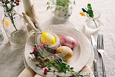 Happy Easter. Stylish easter eggs on a napkin with spring flowers on white wooden background Stock Photo