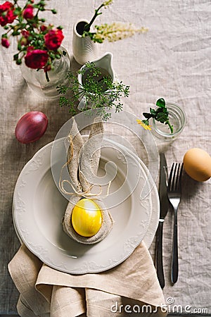 Happy Easter. Stylish easter eggs on a napkin with spring flowers on white wooden background Stock Photo