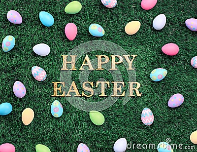 Happy Easter text surrounded with colorful Easter eggs on grass Stock Photo