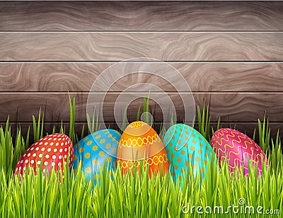 Happy Easter wooden background with colorful painted eggs and green grass. Stock Photo