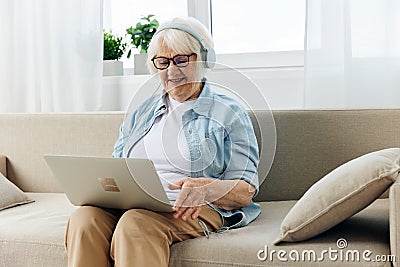 a happy elderly woman in beautiful clothes learns new things and follows trends by learning about the current with the Stock Photo