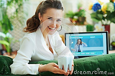 Happy elegant female with tooth and opened digital dental site Stock Photo