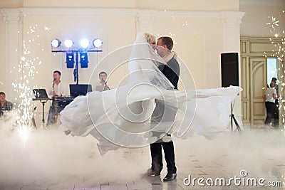 happy elegant married couple performing first dance in a restaurant, celebrating wedding Stock Photo