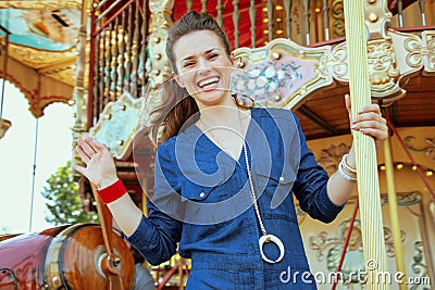 Happy elegant woman riding on carousel and waving Stock Photo