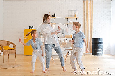 Happy emotional dance of mother with her two children, active modern family Stock Photo