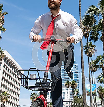 Happy employee have fun scooting along city street, escooter Stock Photo