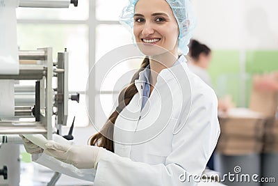 Happy employee wearing lab coat while handling sterile wipes in Stock Photo