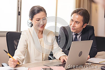 Happy employees discussing potential business Two knowledgeable business people working together with laptops while talking about Stock Photo