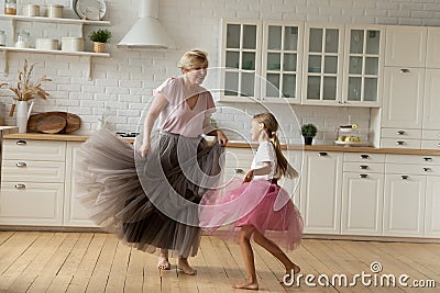 Happy energetic grandmother teach ball dances active little girl grandchild Stock Photo