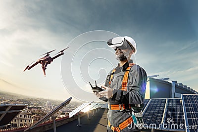 Happy engineer using drone and vr helmet for cheking solar station. in roof Stock Photo