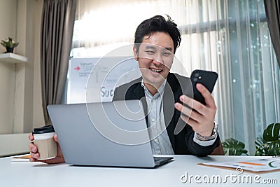 Happy entrepreneur businessman in formal wear work on laptop computer in office with smile face. Attractive business owner man tal Stock Photo