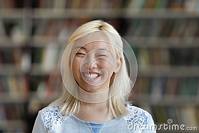 Happy excited Asian blonde young woman head shot portrait Stock Photo