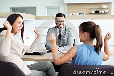 Happy and excited family celebrating just bought a new car from dealership Stock Photo