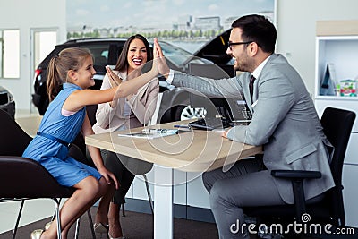 Happy and excited family celebrating just bought a new car from dealership Stock Photo