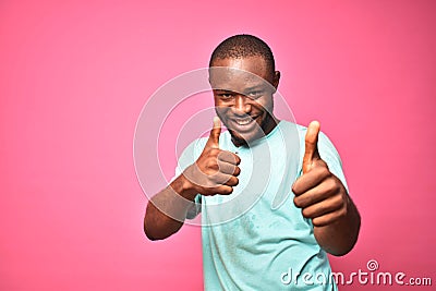 happy and excited handsome young black man giving thumbs up with both hands Stock Photo