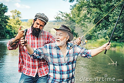 Happy excited man friends. Portrait of cheerful senior man fishing. Grandfather and son fishermans. Young man and an old Stock Photo