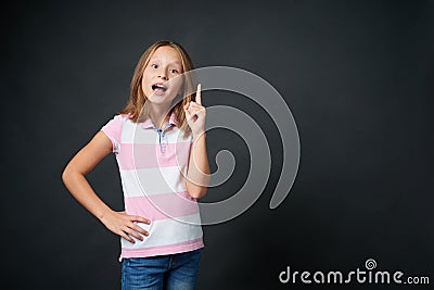Happy excited school age girl pointing finger up Stock Photo