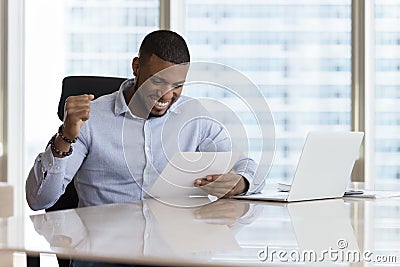Happy excited young Black businessman getting good news letter Stock Photo