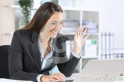 Happy executive greeting on videocall on laptop at office Stock Photo