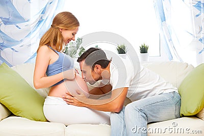 Happy family in anticipation of birth of baby. man kissing belly Stock Photo