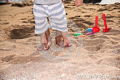 Happy family baby boy and father walk barefoot on sand beach Stock Photo