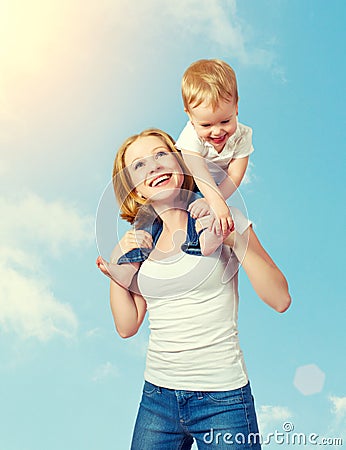 Happy family. baby sits astride the shoulders of the mother and Stock Photo