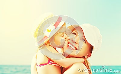 Happy family on beach. baby daughter kissing mother Stock Photo