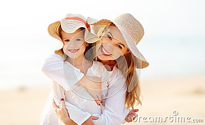 Happy family at beach. mother and child daughter hug at sunset Stock Photo