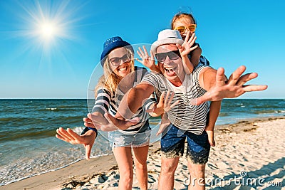 Happy family on the beach. People having fun on summer vacation. Father, mother and child against blue sea and sky background. Stock Photo