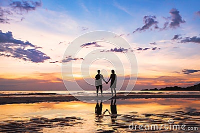 Happy family on the beach, silhouette of couple at sunset, man and woman Stock Photo