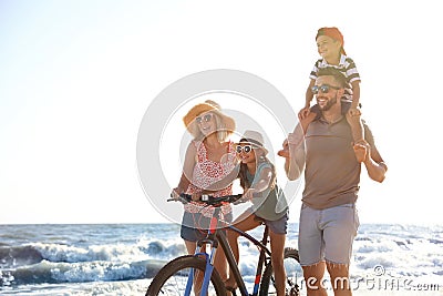 Happy family with bicycle on beach Stock Photo