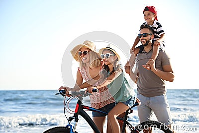 Family with bicycle on beach near sea Stock Photo