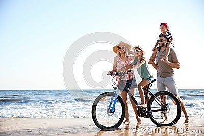 Happy family with bicycle on beach near sea Stock Photo