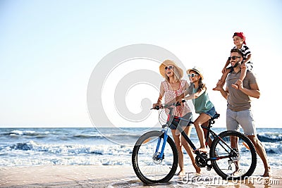 Family with bicycle on sandy beach near sea Stock Photo